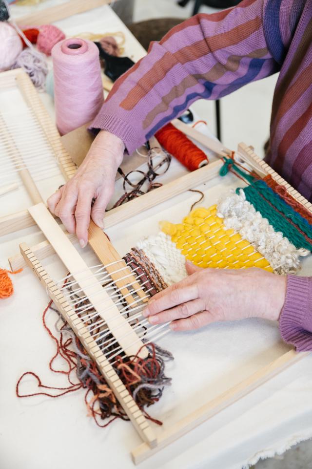 hands weaving on a hand loom