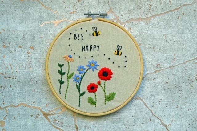 Bee happy embroidery in a circular frame with floral patterns 