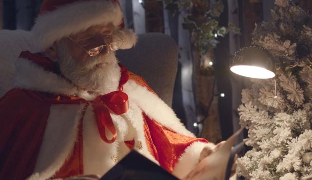 Santa reading a book in his grotto