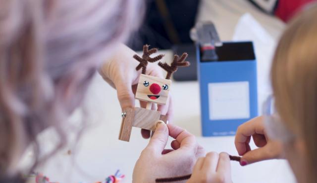 Santa's workshop. Visitors making wooden reindeer