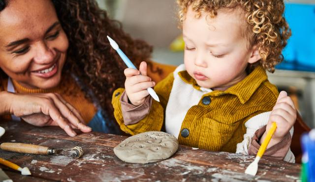 Woman and child playing with clay