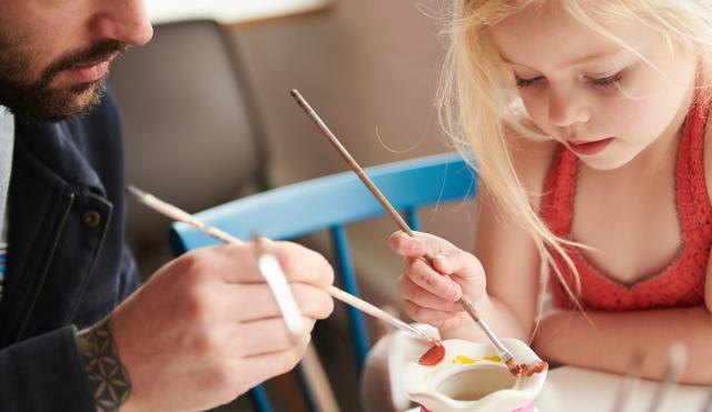 Child and father painting pottery in Decorating Studio