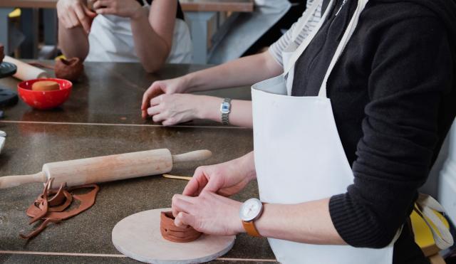 Women in aprons making clay vases