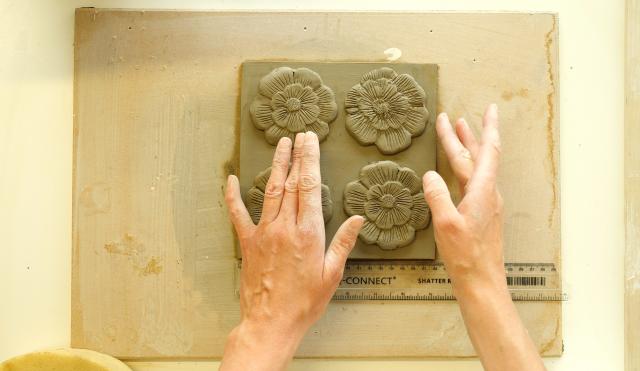 Hands making clay flowers