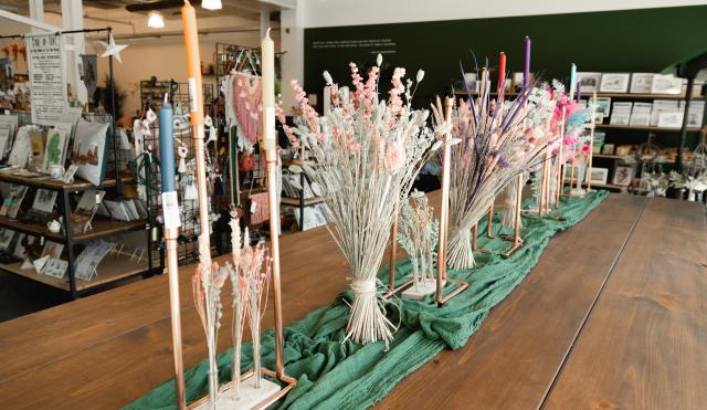 Image of workshop table in Josiah and Co with table decorations of candle sticks and dried flowers