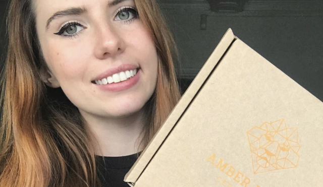 Image of Leone holding a packaging box, branded with Amber Lion Ceramics
