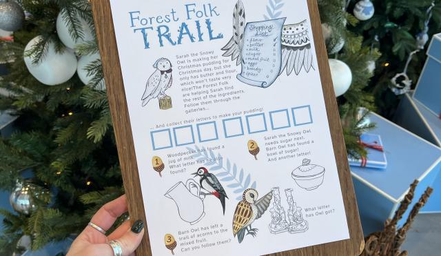 Image of forest folk trail sheet on a wooden board background.